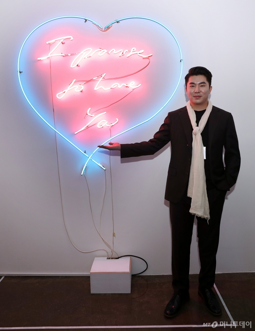 트레이시 에민의 작품 'I Promise to love you' 옆에서 사진 촬영에 응한 송자호 피카갤러리 공동대표. /사진=김휘선 기자