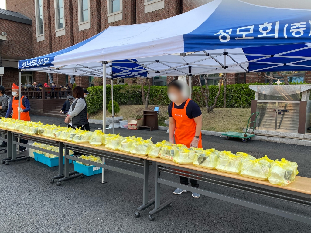 우엉조림을 밥에 올리는 봉사자들./사진=남형도 기자