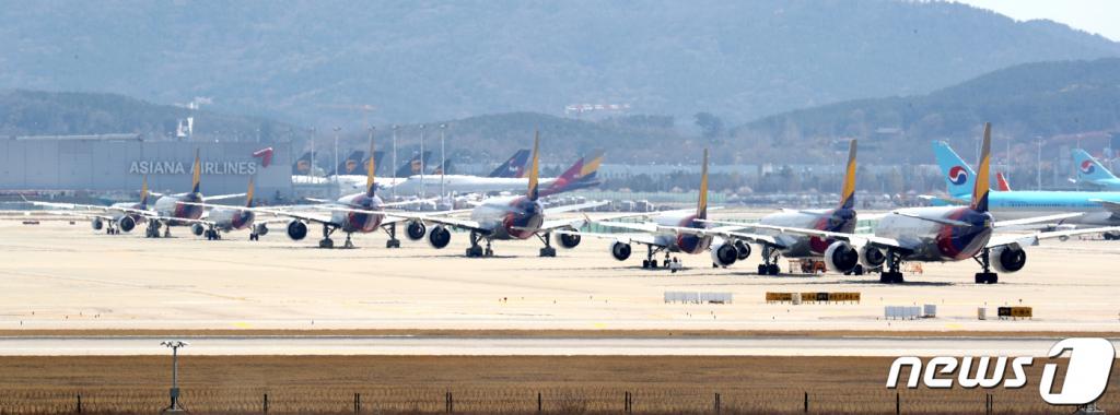 (인천공항=뉴스1) 황기선 기자 = 13일 인천국제공항 계류장에 비행기가 계류돼 있다. 신종 코로나바이러스 감염증(코로나 19) 여파로 공항 기능을 축소하는 1단계 비상운영 중인 인천국제공항공사는 2단계 비상운영 체제 가동을 고심하고 있다. 2단계 비상운영에 돌입하면 활주로 일부를 폐쇄하고, 주로 저비용항공사가 이용하는 탑승동 운영도 중단한다. 2020.4.13/뉴스1