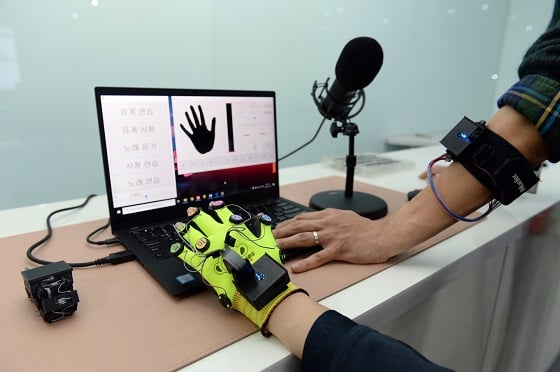 ETRI 연구진이 개발한 학습 소프트웨어와 연동된 촉각 피치 시스템의 장갑형 버전과 밴드형 버전/사진=ETRI