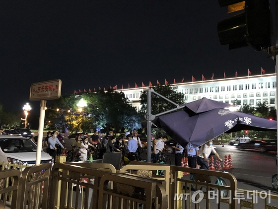 22일 자전거를 타고 톈안먼 앞을 지나려는 이들이 경찰에 신분증을 제시하고 있다./사진=김명룡