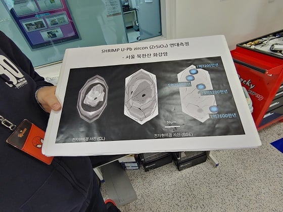 고분해능 이차이온질량분석기(모델명: HR-SIMS)로 분석한 광물의 가장 안쪽 나이, 중간 나이, 바깥쪽 나이 등 부분별 연대측정값이 표시된 자료를 관계자가 들어보이고 있다/사진=류준영 기자
