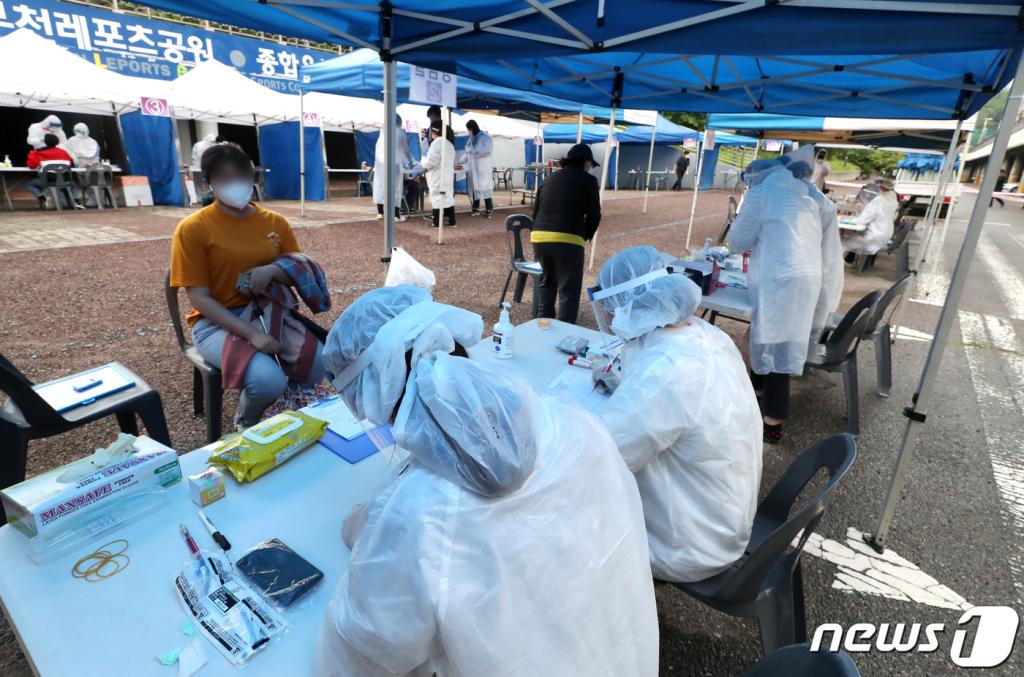 (부천=뉴스1) 정진욱 기자 = 경기 부천 쿠팡 물류센터발 신종 코로나바이러스 감염증(코로나19)확진자가 무더기로 발생한 가운데, 방역당국이 센터 근로자 등 관련자 3626여명을 대상으로 검체 검사를 진행한다. 대상자는 12일부터 25일까지 물류센터 상시 근무자, 일용직 근로자, 납품업체 직원, 퇴직자가 포함됐다. 쿠팡 물류센터 근로자들이 26일 부천 종합운동장에 마련된 선별진료소에서 검사를 받고 있다.2020.5.26/뉴스1