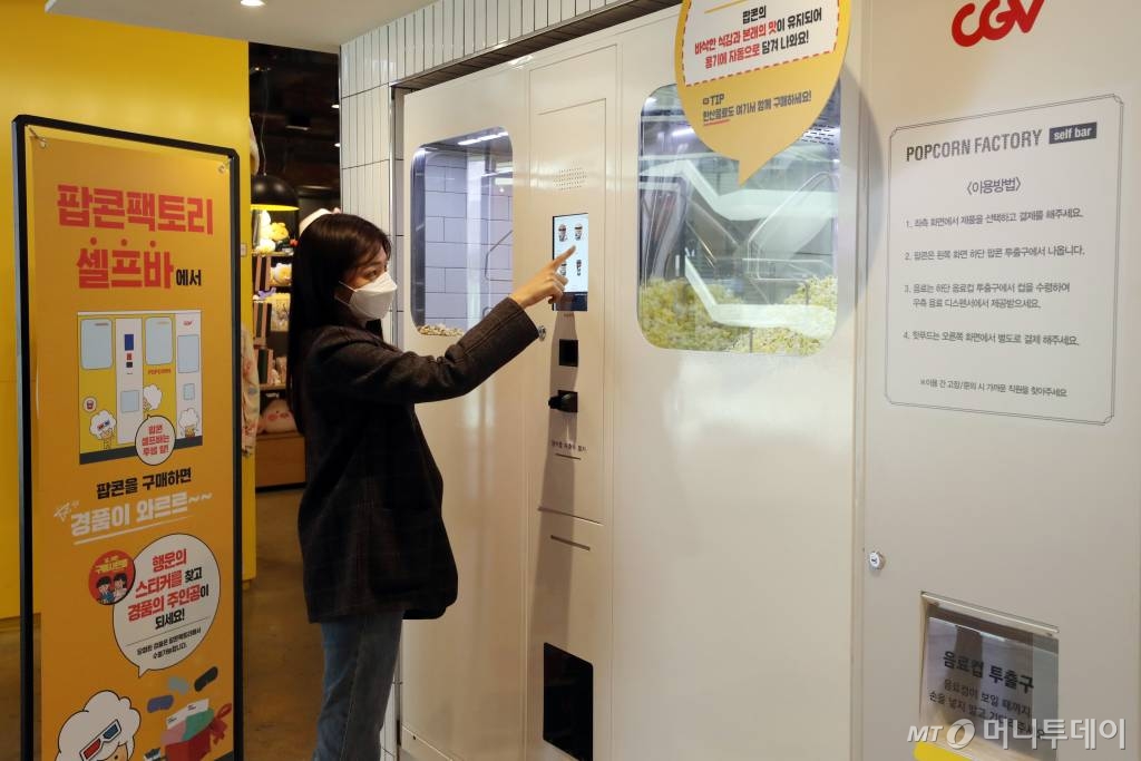 CJ CGV가 대면 서비스를 최소화한 '언택트시네마'를 선보인 가운데 지난달 21일 서울 CGV 여의도에서 한 시민이 직원과 대면 없는 셀프 벤딩머신을 이용해 팝콘을 구매하고 있다. '언택트시네마'는 다양한 하이테크 기술을 통해 언택트(Un-tact) 서비스를 기반으로 새롭고 간편하게 극장 시설을 이용할 수 있는 서비스다. / 사진=이기범 기자 leekb@