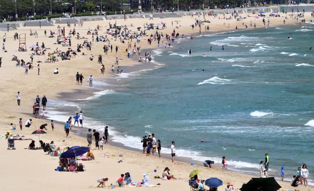 전국적으로 무더위가 찾아온 7일 오후 부산 해운대해수욕장을 찾은 시민들이 코로나19 예방을 위한 거리두기를 한 채 물놀이와 일광욕을 즐기고 있다. /사진=뉴시스