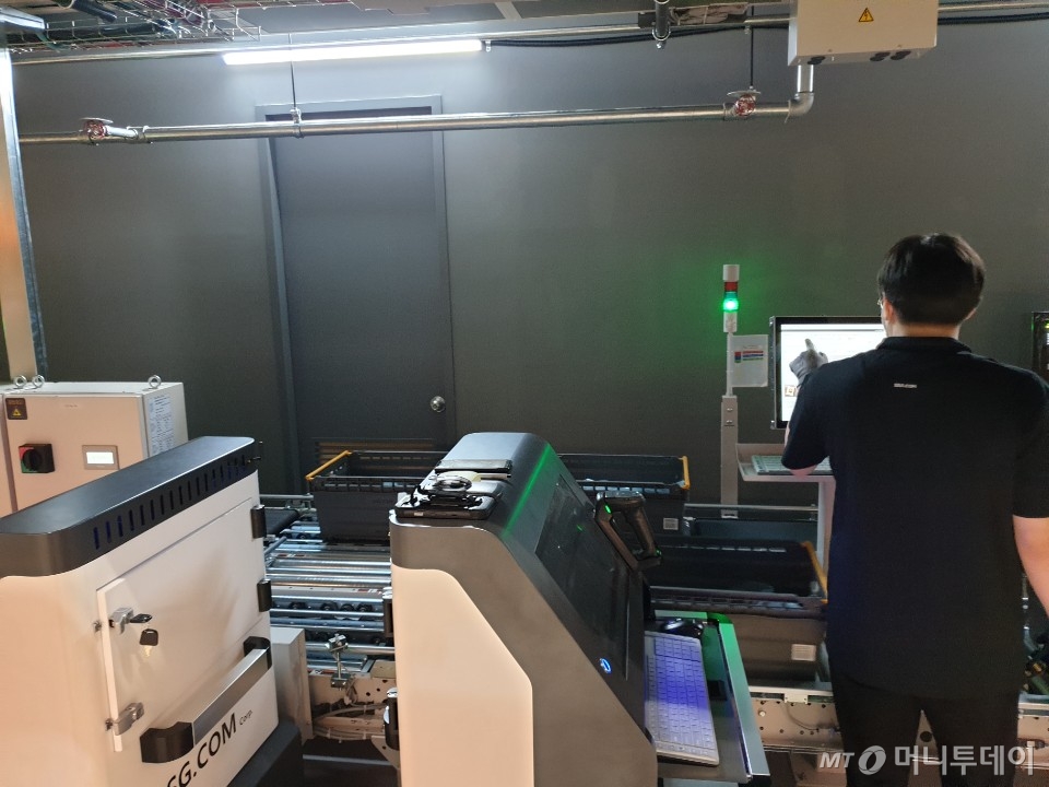 SSG닷컴의 로봇활용 O2O 매장 '이마트 온라인 스토어'(EO.S) 청계천점에서 직원이 물류 업무를 보고 있다. 컨베이어 벨트가 깔린 DPS(Digital Picking System), 상품이 작업자를 자동으로 찾아오는 GTP(Good To Person) 시스템 등이 눈에 띈다. /사진=이재은 기자