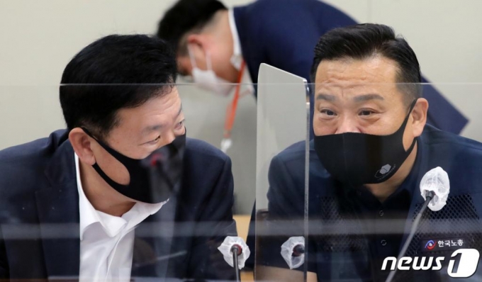 (세종=뉴스1) 장수영 기자 = 류기정 사용자위원(왼쪽)과 이동호 근로자위원(오른쪽)이 11일 정부세종청사 고용노동부 전원회의장에서 열린 최저임금위 첫 전원회의에서 대화를 나누고 있다.  내년도 최저임금 논의 과정 중 가장 큰 변수는 코로나19로 인한 영향일 것으로 예측되고 있다. 이 날 첫 회의에는 민주노총 소속 근로자위원들은 불참했다. 2020.6.11/뉴스1