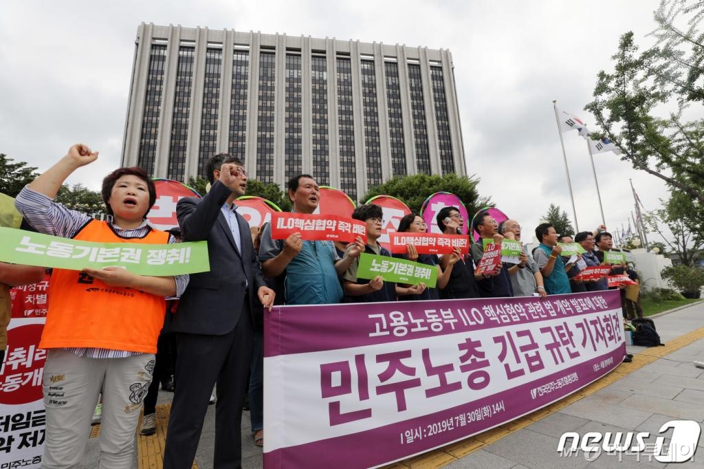(서울=뉴스1) 박세연 기자 = 민주노총 노조원들이 30일 오후 종로구 세종대로 정부서울청사 앞에서 '고용노동부 ILO 핵심협약 관련 법 개악 발표에 대한 규탄 기자회견'을 갖고 구호를 외치고 있다. 2019.7.30/뉴스1