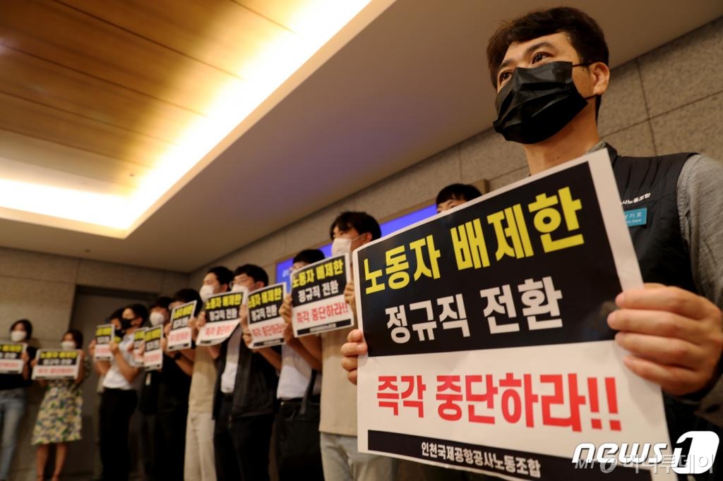 (인천공항=뉴스1) 정진욱 기자 = 구본환 인천국제공항공사 사장이 22일 오후 인천공항1터미널에서 기자회견을 예고한 가운데 정규직 전환에 반대하는 정규직 노조 소속 노동자들이 피켓을 들고 항의하고 있다. 인천공항공사는 22일 인천공항 보안요원 1900여명을 정규직화 한다고 밝혔다.2020.6.22/뉴스1