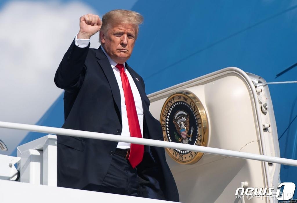 (그린베이 AFP=뉴스1) 우동명 기자 = 도널드 트럼프 미국 대통령dl 25일 (현지시간) 위스콘신주 그린베이에 있는 오스틴 스트로벨 국제공항에서 전용기를 타고 주먹을 불끈 쥐고 있다. ⓒ AFP=뉴스1
