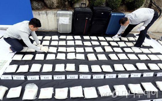 서울지방경찰청 광역수사대가 15일 오전 서울 종로구 내자동 서울지방경찰청 주차장에서 대량의 필로폰을 밀반입ㆍ유통한 국내외 마약조직을 검거한 후 압수한 필로폰 90kg 및 기타 증거자료를 공개하고 있다.   광역수사대는 필로폰 112kg을 밀반입한 후 일부를 유통한 대만인 3명과 이들로부터 필로폰을 구매ㆍ재판매한 일본인과 내국인 등 5명을 검거, 이중 6명을 구속하고 보관중이던 시가 3,000억 원 상당의 필로폰 90kg을 압수했다.   한편 경찰은 국제화되는 마약 범죄 추세에 적극 대응해 국정원ㆍ관세청 등 유관 기관과의 정보 공유 및 협력을 더욱 강화하고 해외 법집행기관과의 공조 체계를 확립해 나갈 것이라고 밝혔다. 2018.10.15/뉴스1