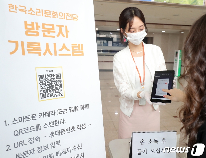 전북도 관리 공공시설에 대한 전자출입명부 시스템 도입 운영이 실시된 1일 전북 전주시 한국소리문화의전당 연지홀에서 한 방문객이 입장을 위해 일회용 QR코드 발급 절차를 진행하고 있다. 2020.7.1 © News1 유경석 기자