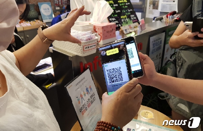 제주도의 한 업소에서 QR코드 인증 절차를 진행하는 도민들 © 뉴스1 오현지 기자