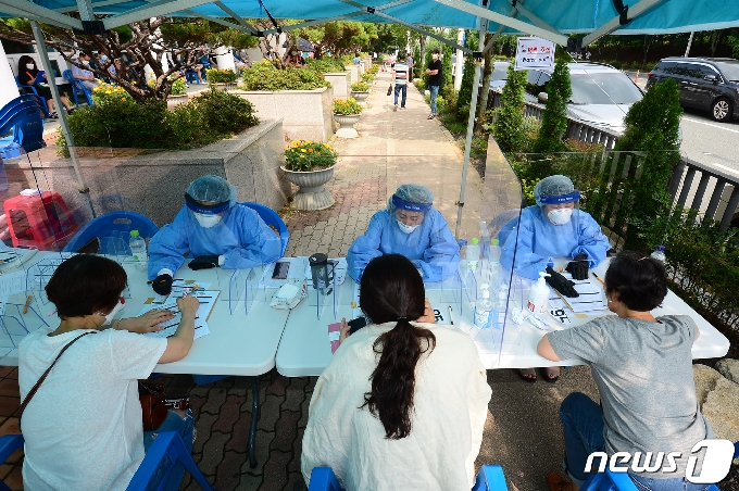 7일 오후 광주 광산구 신창동 행정복지센터에 설치된 임시 신종 코로나바이러스 감염증(코로나19) 선별진료소에서 보건소 관계자들이 문진하고 있다.. 2020.7.7 /뉴스1 © News1 한산 기자