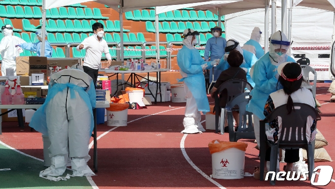 지역 내 감염이 이어지고 있는 17일 오전 제주시 한림읍 한림체육관에 마련된 워킹스루 선별진료소에서 주민들이 검체검사를 받고 있다. 해열제를 먹으며 5박6일간 제주여행을 한 뒤 확진 판정을 받은 서울 광진구 20번 확진자 A씨와 관련된 제주도내 2차 감염자가 현재까지 4명으로 늘었다.2020.7.17 /뉴스1 © News1 오현지 기자