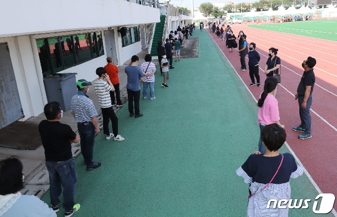 지역 내 감염이 이어지고 있는 17일 오전 제주시 한림읍 한림체육관에 마련된 워킹스루 선별진료소가 주민들로 붐비고 있다. 해열제를 먹으며 5박6일간 제주여행을 한 뒤 확진 판정을 받은 서울 광진구 20번 확진자 A씨와 관련된 제주도내 2차 감염자가 현재까지 4명으로 늘었다.2020.7.17 /뉴스1 © News1 오현지 기자