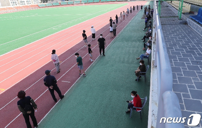 지역 내 감염이 이어지고 있는 17일 오전 제주시 한림읍 한림체육관에 마련된 워킹스루 선별진료소가 주민들로 붐비고 있다. 해열제를 먹으며 5박6일간 제주여행을 한 뒤 확진 판정을 받은 서울 광진구 20번 확진자 A씨와 관련된 제주도내 2차 감염자가 현재까지 4명으로 늘었다.2020.7.17/뉴스1 © News1 오현지 기자