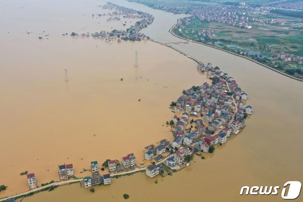 (주장 AFP=뉴스1) 지난 13일(현지시간) 중국 장시성 주장에 폭우로 하천 댐이 무너지면서 물에 잠긴 도로와 건물의 모습이 보인다. ⓒ AFP=뉴스1