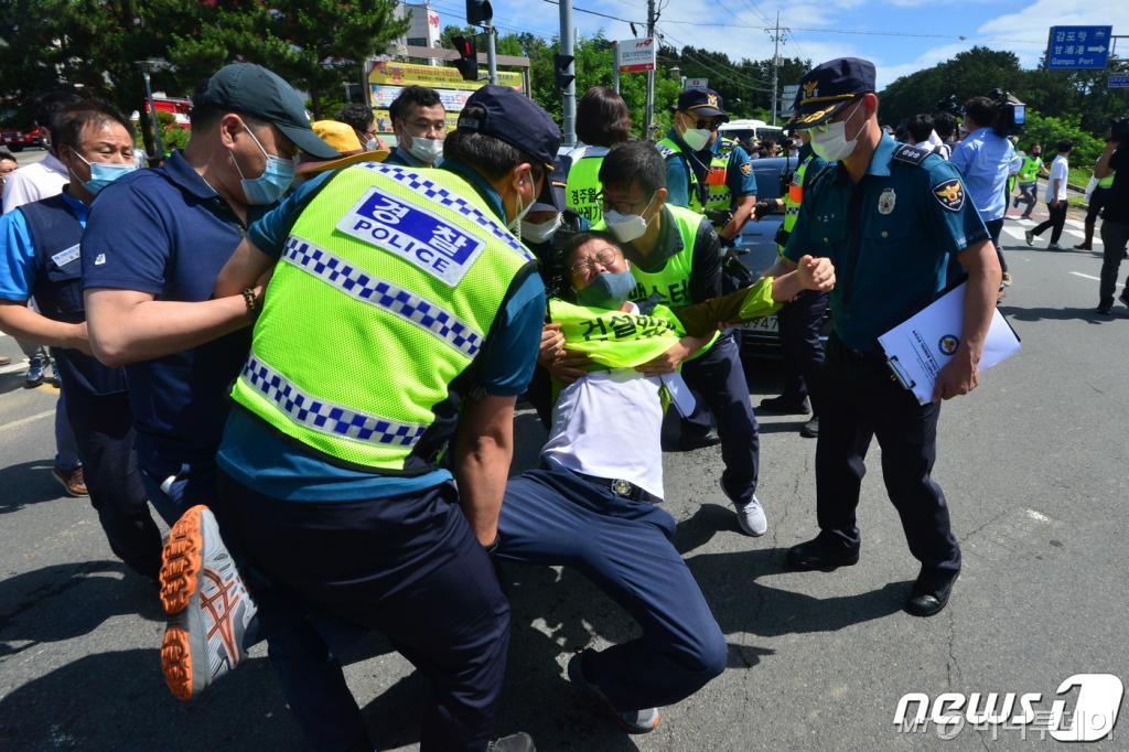 (경주=뉴스1) 최창호 기자 = 24일 오후 경북 경주시 감포읍 감포복지회관 앞 도로에서 한국수력원자력(주)월성원자력본부 사용후핵연료 임시저장시설(맥스터)증설을 반대하는 시민이 김소영 사용후핵연료 임시저장시설(맥스터) 재검토위원장이 탄 승용차를 막아서자 경찰이 이를 제지하고 있다. 사용후핵연료 임시저장시설(맥스터) 재검토위원회는 이날 주민의견수렴결과를 발표할 예정이었지만 반대단체의 반발에 무산돼 서류로 대신했다. 주민의견수렴 결과 찬성 81.4%, 반대11%, 모르겠다 7.6%로 나타났다. 2020.7,25/뉴스1
