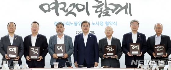 문재인 대통령(가운데)이 지난 28일 서울 종로구 경제사회노동위원회 대회의실에서 열린 경제사회노동위원회의 ‘코로나19 위기 극복을 위한 노사정 협약식’을 끝낸 참석자들과 ‘여럿이 함께’ 문구가 적힌 기념패를 들고 기념촬영을 하고 있다. 사진 왼쪽부터 홍남기 부총리 겸 기획재정부 장관, 박용만 대한상공회의소 회장, 김동명 한국노총 위원장, 문 대통령, 손경식 한국경영자총협회 회장, 이재갑 고용노동부 장관, 문성현 경사노위 위원장./사진=[서울=뉴시스]박영태 기자