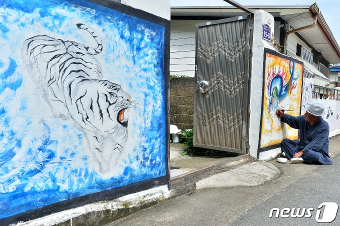 초충도(草蟲圖) 명인 이철우 화백이 31일 오후 경북 포항시 북구 용흥동 주택가 벽에 호랑이와 용 벽화를 그리고 있다. 2020.7.31/뉴스1 © News1 최창호 기자