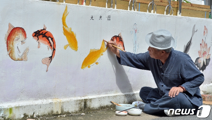 초충도(草蟲圖) 명인 이철우 화백이 31일 오후 경북 포항시 북구 용흥동 주택가 벽에 물고기 벽화를 그리고 있다. 2020.7.31/뉴스1 © News1 최창호 기자