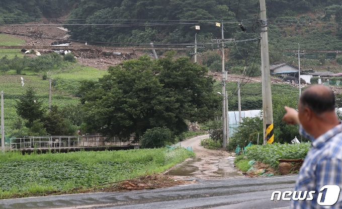 김씨가 과거 사과나무밭이었지만 과수화상병으로 매몰하면서 맨땅으로 변해 산사태가 발행한 곳을 가르키고 있다.  © 뉴스1 김용빈 기자
