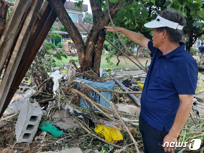 산양1리 이장 이종근씨가 지난 2일 산양저수지 둑 붕괴로 마을에 물이 차올랐던 당시 상황을 손으로 가리키며 설명하고 있다.© 뉴스1 유재규 기자