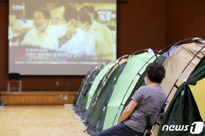 제5호 태풍 '장미'가 북상한 10일 오후 전남 구례군 구례여자중학교 체육관에서 지난 폭우로 침수 피해를 입은 수재민들이 대피해 뉴스를 보고 있다. 2020.8.10/뉴스1 © News1 황희규 기자
