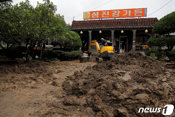 12일 오전 섬진강이 범람하며 침수피해를 입은 전남 순천시 황전면의 식당 마당에 중장비가 들어가 진흙은 걷어내고 있다. 이 지역은 구례와 섬진강을 사이에 두고 순천행정구역인 지역으로 약 4킬로미터의 강변을 따라 40여 상가와 주택이 자리하고 있고 , 대부분 홍수피해를 입었다.2020.8.12/뉴스1