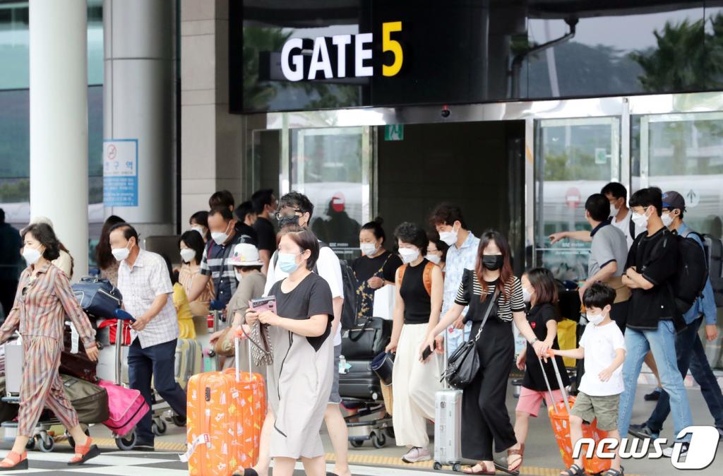 (제주=뉴스1) 오현지 기자 = 본격적인 여름 휴가철을 맞은 7일 오전 제주국제공항에서 관광객들이 횡단보도를 건너고 있다.2020.8.7/뉴스1