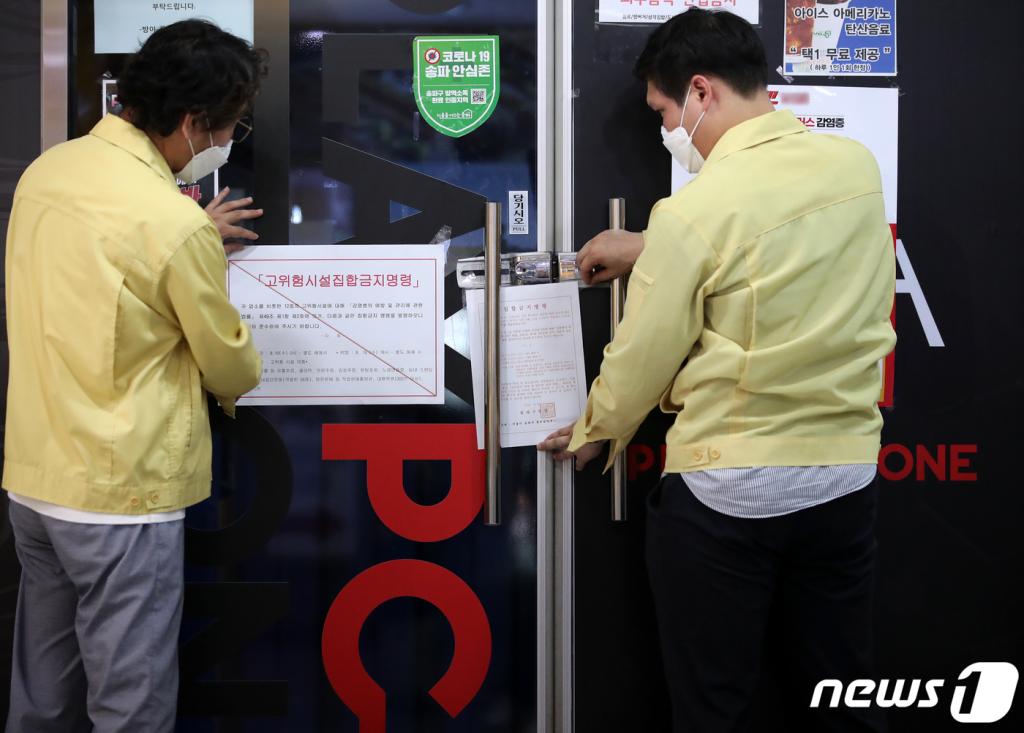 19일 오후 서울 송파구 일대에서 구청 관계자가 한 pc방에 코로나19 확산 억제를 위한 집합금지명령문을 붙이고 있다. /사진=뉴스1