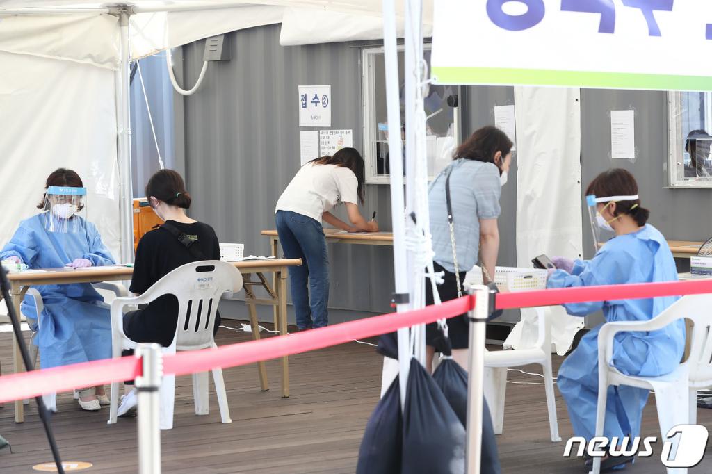 24일 오전 서울 성북구 성북구청 앞에 마련된 코로나19 선별진료소를 찾은 시민들이 검사를 받기 위해 문진표를 작성하고 있다. /사진=뉴스1