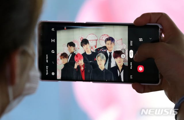 [서울=뉴시스] 고범준 기자 = 그룹 BTS(방탄소년단)의 첫 영어 싱글 '다이너마이트'가 빌보드 싱글차트 1위를 차지한 가운데 1일 오후 서울 중구 롯데면세점에 BTS 광고를 한 시민이 촬영하고 있다. K팝의 역사를 새로 쓴 BTS는 한국 가수 사상 최초로 미국 빌보드 메인 싱글 차트 '핫 100' 정상에 올랐다. 2020.09.01.   bjko@newsis.com