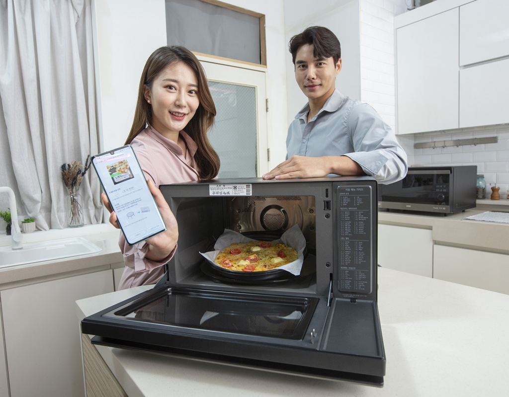 LG전자가 최적의 조리법을 찾아주는 ‘디오스 광파오븐’ 제품군을 확대한다. 모델들이 39L 용량 신제품(모델명: ML39PTW)을 소개하고 있다/사진제공=LG전자