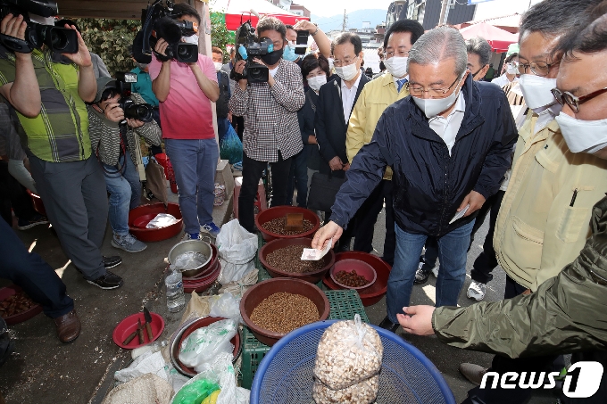 김종인 국민의힘 비상대책위원장이 28일 오후 전남 구례5일시장을 찾아 지난달 초 폭우로 인해 침수피해를 입은 상인에게 뻥튀기를 사기위해 돈을 건네고 있다.2020.9.28/뉴스1 © News1 황희규 기자