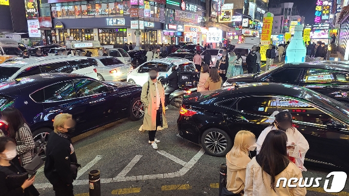 핼러윈데이를 하루 앞둔 30일 밤 경기 수원시 인계동 무비사거리 일대. 차량과 인파가 뒤섞여 혼잡을 이루고 있다. © 뉴스1