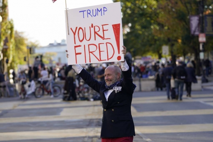 [워싱턴=AP/뉴시스]6일(현지시간) 미 워싱턴 백악관 인근 흑인 생명 소중(BLM) 광장에서 시위대가 모든 표의 개표를 촉구하는 시위를 하는 가운데 한 남성이 "트럼프, 해고"라는 팻말을 들고 있다. 2020.11.07.