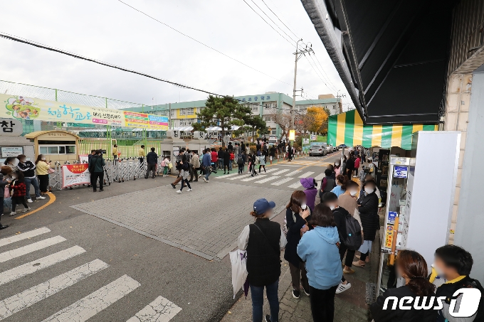 광주·전남지역에서 신종 코로나바이러스 감염증(코로나19) 확진자가 급증하고 있는 18일 오후 광주 서구 염주초등학교 앞에서 학부모들이 코로나19 검사를 받고 하교하는 자녀들을 기다리고 있다. 2020.11.18 /뉴스1 © News1 황희규 기자