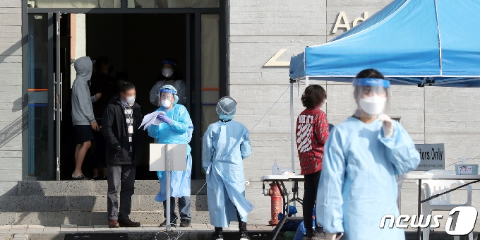 20일 오전 확진자가 발생한 제주 서귀포시 대정읍 영어교육도시 내 한 국제학교의 재학생들이 학교에 마련된 워킹스루 진료소에서 검체검사를 받고 있다.2020.11.20 /뉴스1 © News1 오현지 기자