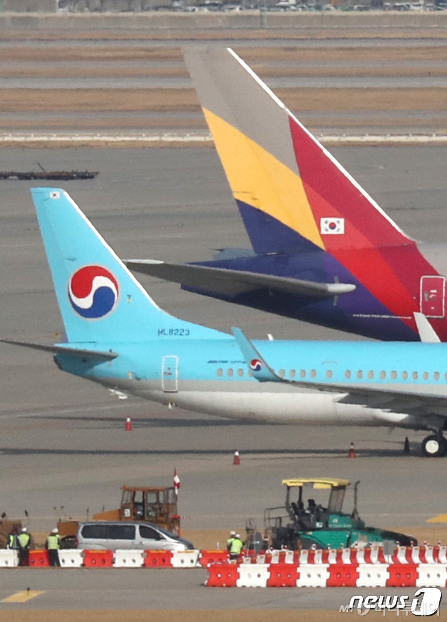 (서울=뉴스1) 이성철 기자 = KCGI 측이 한진칼을 상대로 낸 신주발행 금지 가처분 신청에 대한 인용·기각 여부가 결정되는 1일 오후 인천국제공항 주기장에 대한항공과 아시아나항공 여객기가 이륙준비를 하고 있다. 가처분 신청이 기각되면 한진그룹에 속한 대한항공과 아시아나항공의 통합 작업이 급물살을 타며 ‘원톱’ 항공사 체제가 본격화될 것으로 전망된다. 반면 가처분 신청이 인용되면 대한항공과 아시아나항공 통합은 무산된다. 2020.12.1/뉴스1