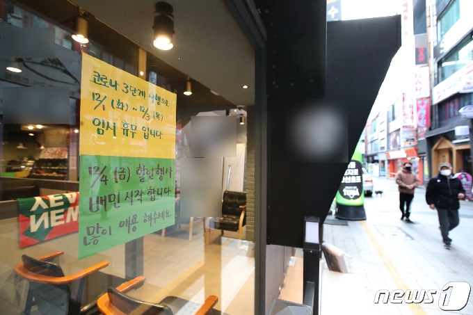 부산시에 사회적 거리두기 2단계가 시행된 첫 날인 1일 오후 부산 부산진구 서면의 한 카페에 코로나19 확산 방지 동참을 위한 자진 휴무 안내문이 붙어 있다. 2020.12.1/뉴스1 © News1 여주연 기자