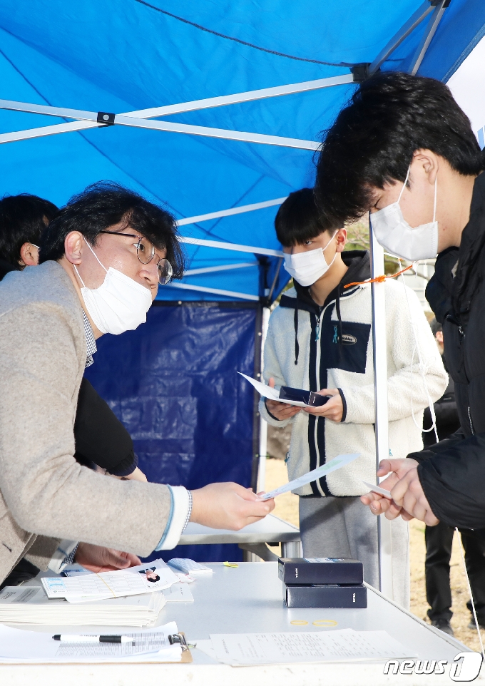 2021학년도 대학수학능력시험을 하루 앞둔 2일 오전 제주 오현고등학교 기숙사 앞 워킹스루에서 마스크를 쓴 수험생들이 수험표를 받고 있다.2020.12.2/뉴스1 © News1 오미란 기자