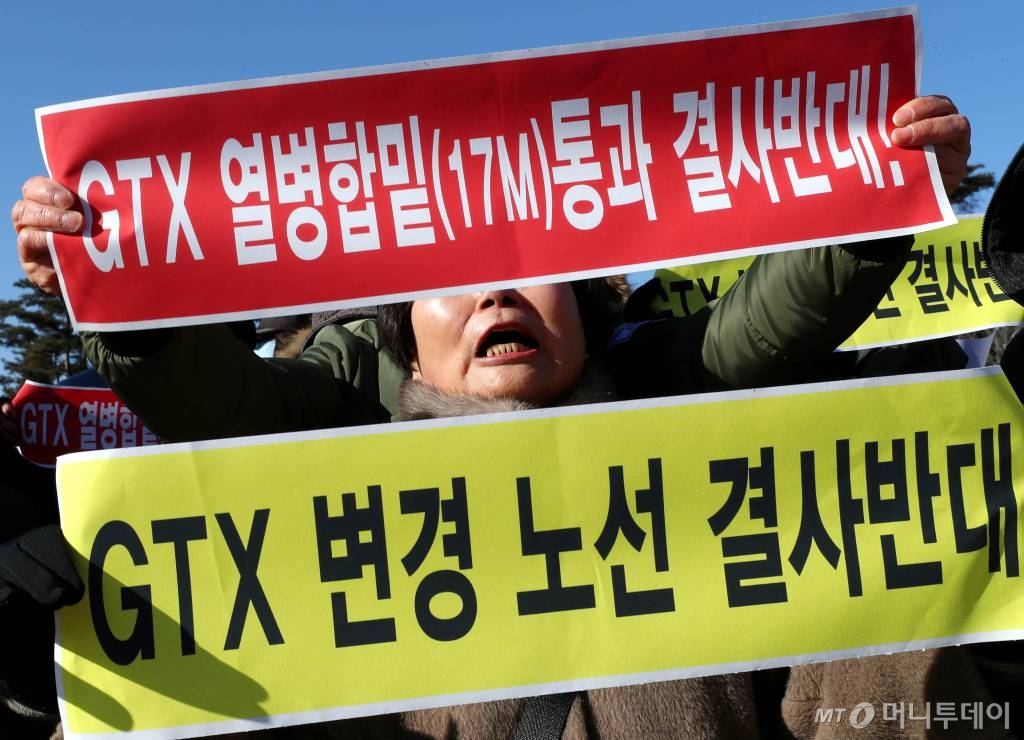 27일 오후 수도권광역급행철도(GTX) A노선 착공기념식이 열리는 경기도 고양시 킨텍스 앞에서 수도권광역급행철도(GTX) 변경 노선을 반대하는 주민들이 구호를 외치고 있다. / 사진=홍봉진 기자 honggga@