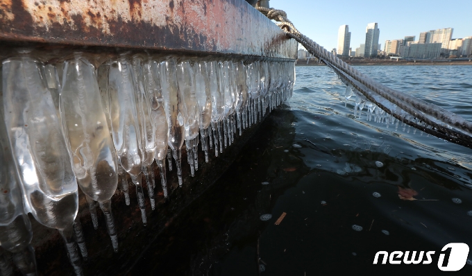 서울을 비롯한 내륙 대부분 지역에 한파특보가 발효된 15일 서울 광진구 뚝섬한강공원에서 선박에 매달려 있는 고드름 뒤로 서울 시내가 보이고 있다. 2020.12.15/뉴스1 © News1 이성철 기자