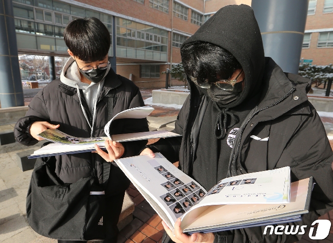 13일서울 한 고등학교에서 졸업식을 끝낸 학생들이 졸업앨범을 보고 있다. 2021.1.13/뉴스1 © News1 사진공동취재단