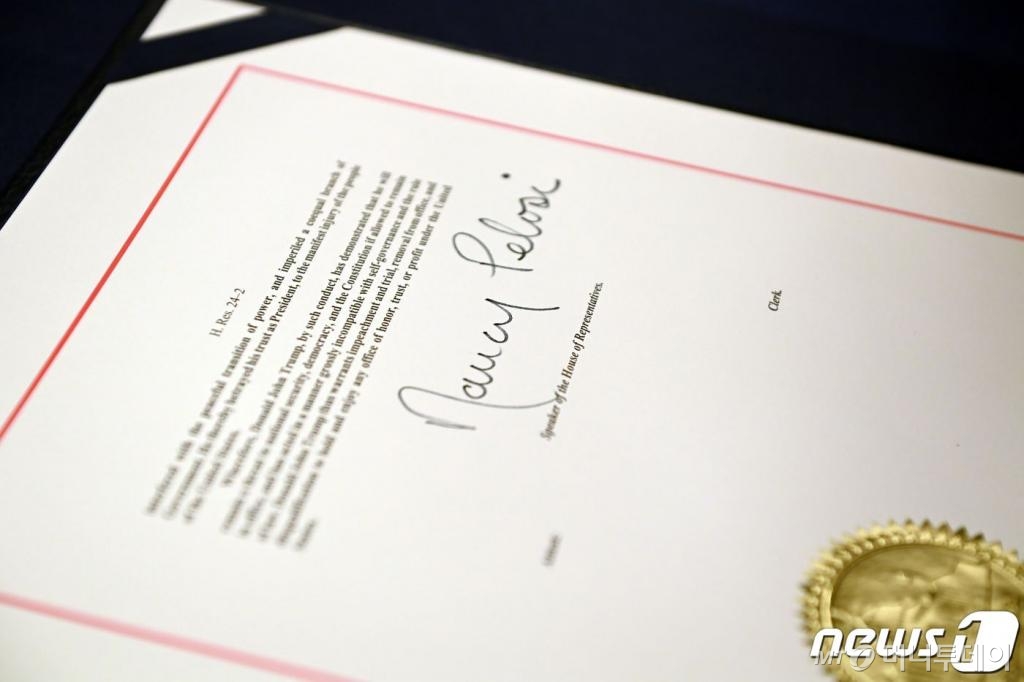 (워싱턴 AFP=뉴스1) 우동명 기자 = 13일(현지시간) 워싱턴 의사당의 하원 본회의장에서 도널드 트럼프 미국 대통령의 탄핵소추안에 낸시 펠로시 하원의장의 서명이 보인다.  ⓒ AFP=뉴스1