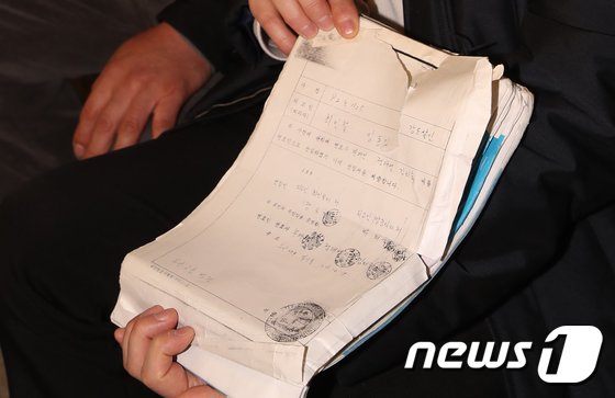 장동익씨와 최인철씨가 지난해 1월 부산 연제구 부산고법 301호에서 열린 재심 재판에 앞서 취재진에게 당시 변호사 선임 서류를 공개하고 있다./사진=뉴스1