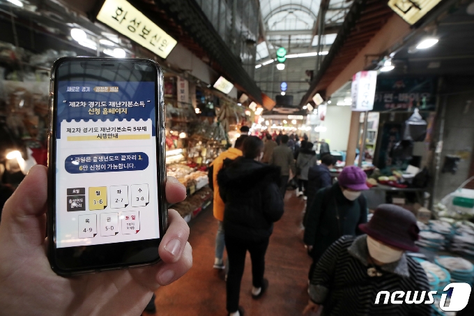 경기도 2차 재난기본소득 신청 첫날인 1일 오전 경기도 수원시 못골시장을 찾은 시민들이 물품을 구매하고 있다. 2차 재난기본소득은 코로나19 확산 방지를 위해 온라인 신청, 현장 수령, 찾아가는 신청서비스 등 3가지 방법으로 지급되며 온라인 신청은 3월14일까지 가능하다. 2021.2.1/뉴스1 © News1 조태형 기자