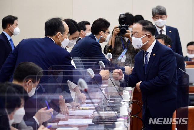 [서울=뉴시스] 홍효식 = 홍남기 경제부총리 겸 기획재정부 장관이 1일 오후 서울 여의도 국회에서 열린 기획재정위원회 전체회의에서 추경호 미래통합당 의원과 인사를 나누고 있다. 2020.09.01.   photo@newsis.com
